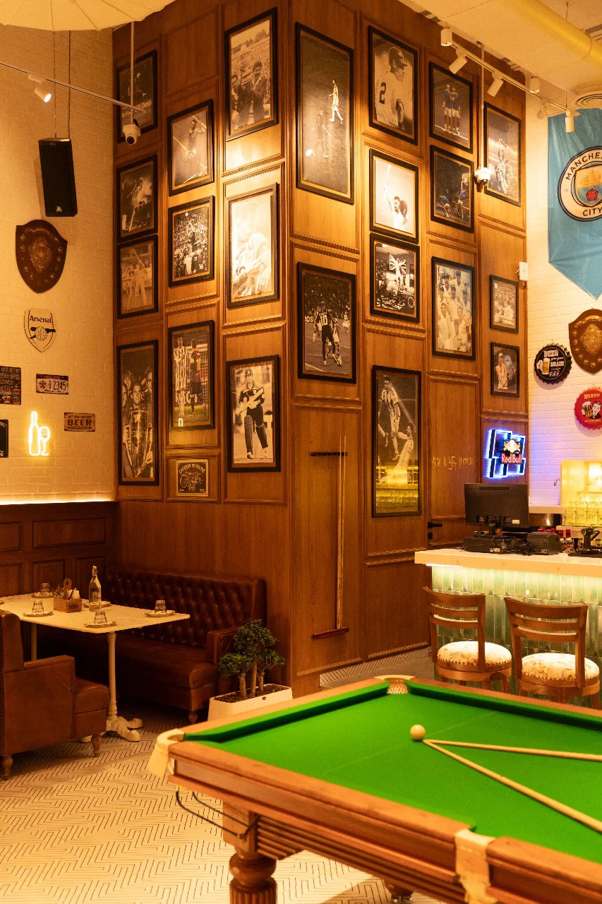 Interior of The Studs restaurant in Pune, featuring a pool table and casual dining arrangement designed by hospitality experts.