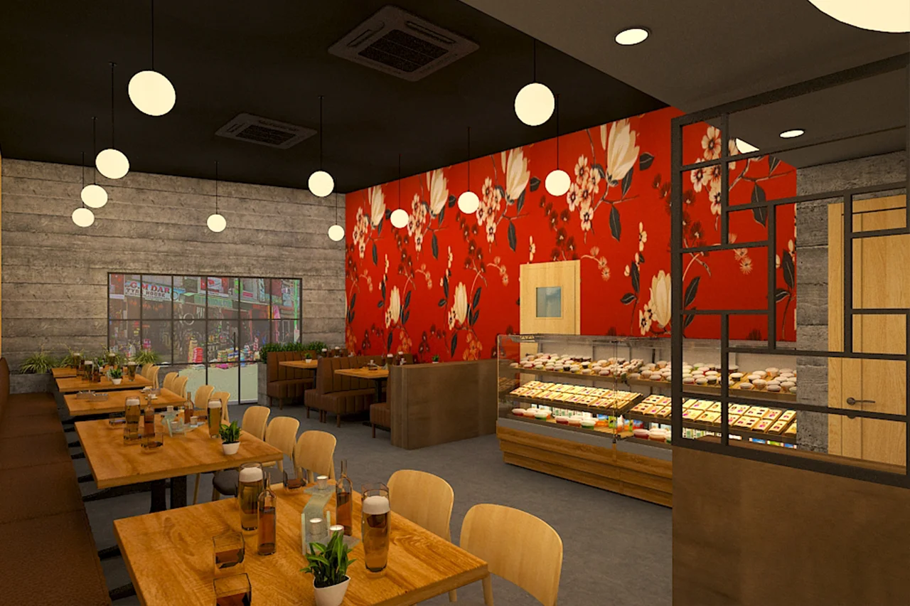 Casual dining area in 5 Spice Ghatkopar featuring a vibrant red feature wall with a white floral pattern and a donut display counter.